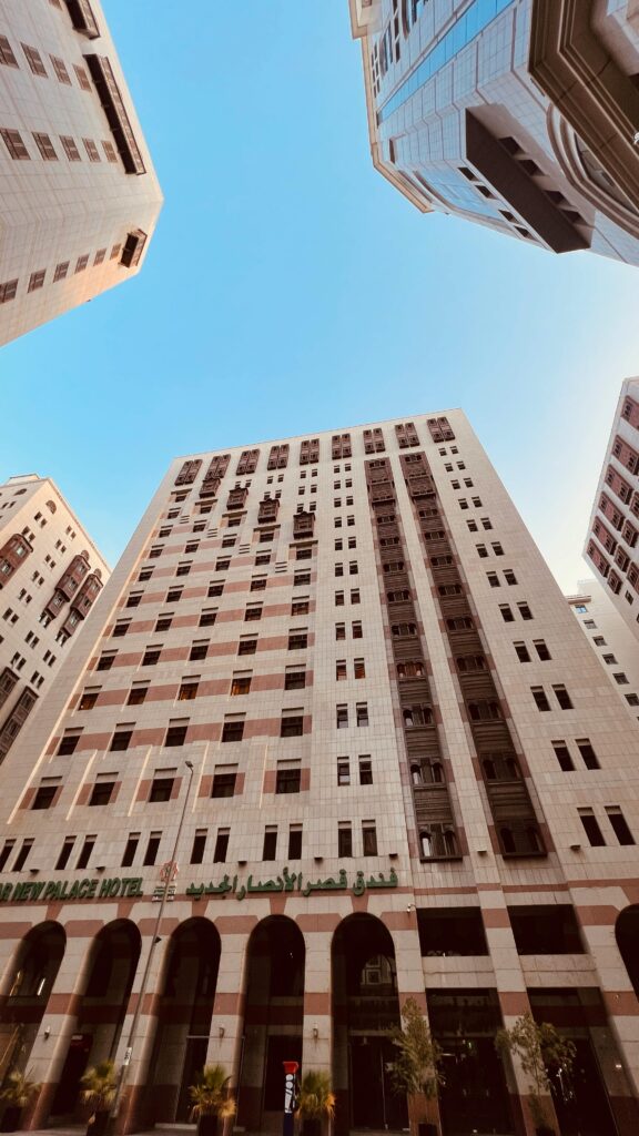 Low angle shot of tall buildings against a bright blue sky in Medina, Saudi Arabia